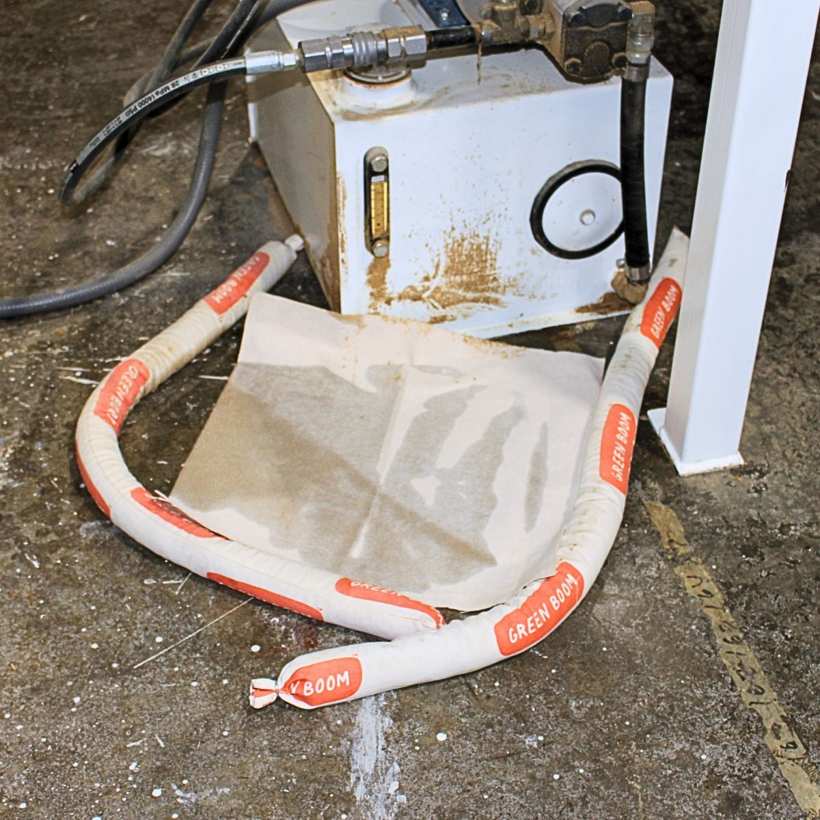 Green Boom-slangen en -matten houden een lekkage bij een pomp tegen